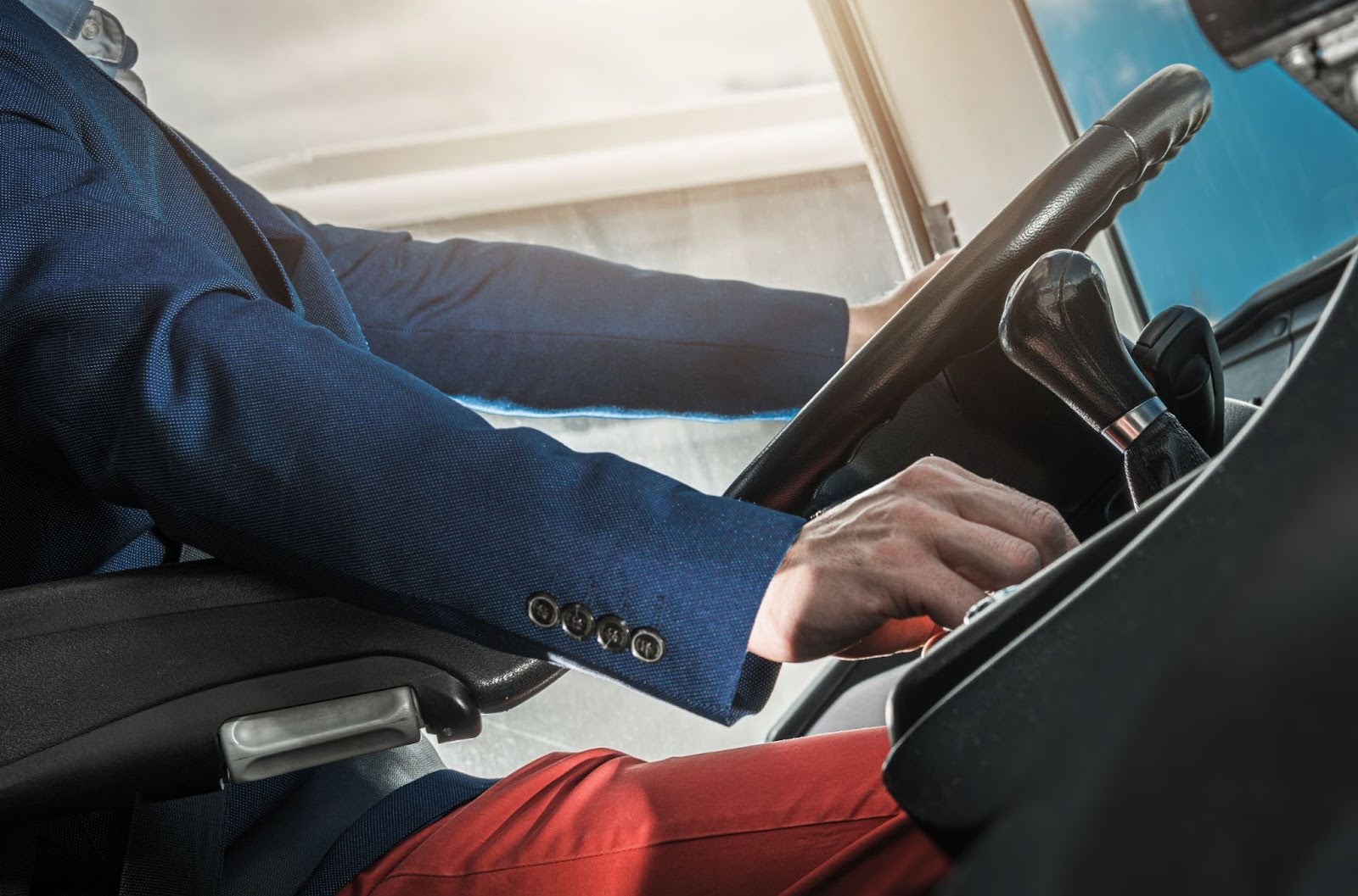 A man in a suit driving a truck with a CDL license.