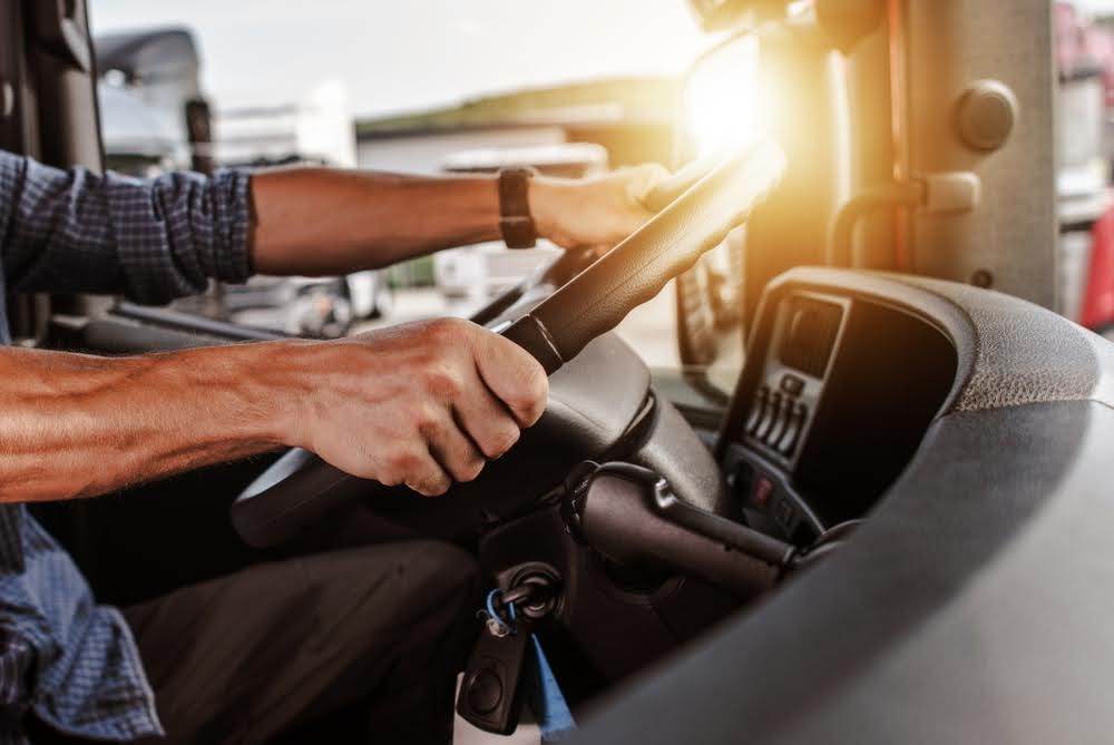 Benefits of CDL license - a truck driver inside of his truck.